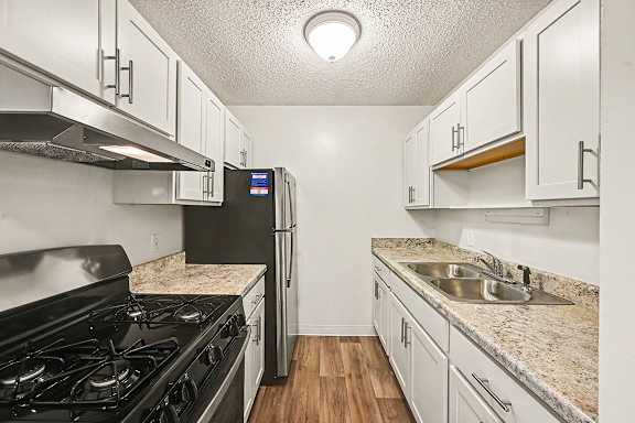 A kitchen with a black stove top oven and a black refrigerator.