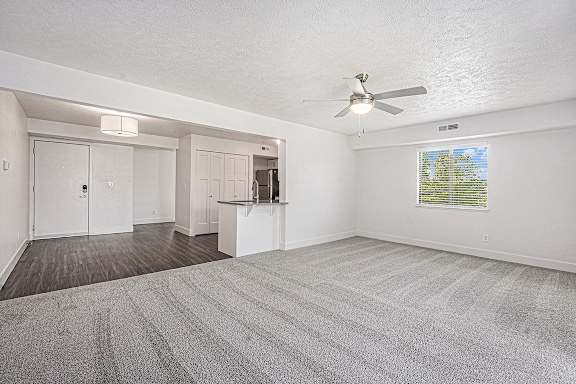An enlarged living room with a ceiling fan and carpeted floor An enlarged living room with a ceiling fan and carpeted floor at Byron Lakes Apartments, Michigan, 49315