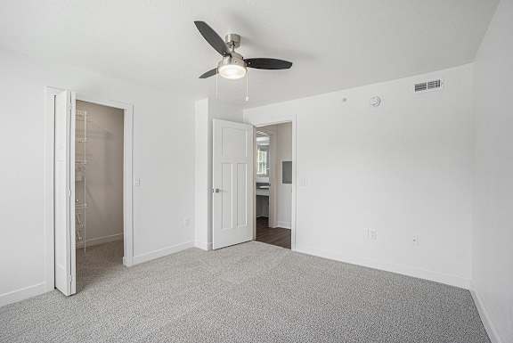 A spacious bedroom with a walk in closet at Byron Lakes Apartments, Byron Center, MI