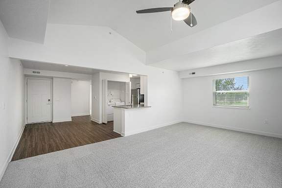 An enlarged living room with a cathedral ceiling, ceiling fan and carpeted floor at Byron Lakes Apartments, Michigan, 49315
