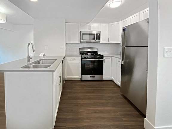 A modern kitchen with stainless steel appliances and white cabinets at Byron Lakes Apartments, Michigan, 49315