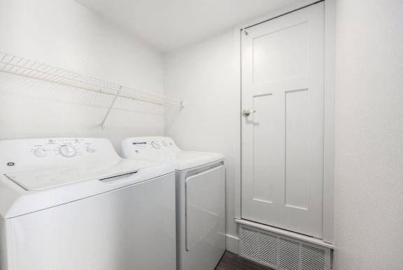 a laundry room with a full size washer and dryer at Byron Lakes Apartments, Byron Center, MI