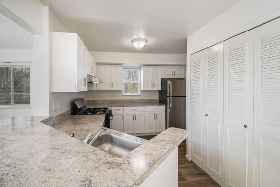 End style kitchen with white cabinets and a window End style kitchen with white cabinets and a window at Canal 2 Apartments in Lansing, MI