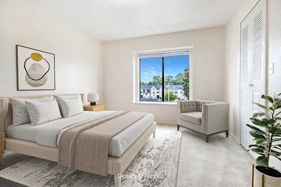 A bedroom with a large window at Canal Club Apartments in Lansing, MI