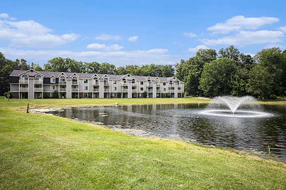 A fountain in the middle of a pond at Canal Club Apartments in Lansing, Michigan