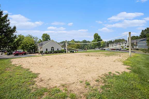 A sandy area with a volleyball court at Canal Club Apartments in Lansing, Michigan