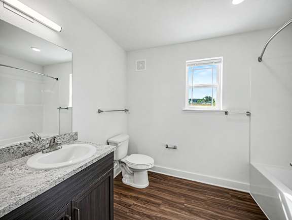 A bathroom with a toilet, sink, window and bathtub at Chase Creek Apartment Homes, Huntsville, AL, 35811