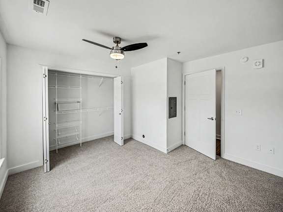 A bedroom with a ceiling fan, walk-in closet and carpeted floor at Chase Creek Apartment Homes, Huntsville, AL, 35811