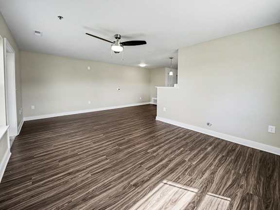 A large living room with a ceiling fan and hard-surface flooring at Chase Creek Apartment Homes, Huntsville, AL, 35811