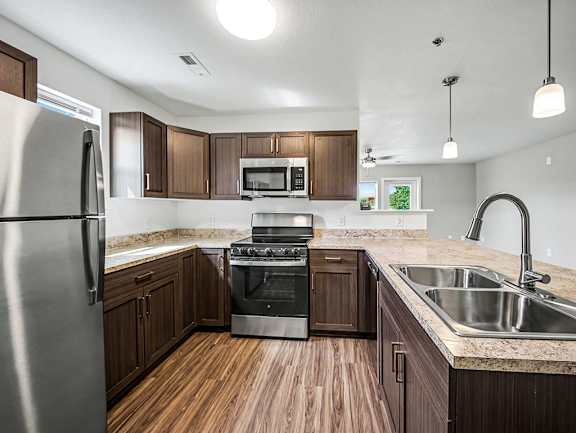 A kitchen with hard-surface floors and stainless steel appliances at Chase Creek Apartment Homes, Huntsville, AL, 35811