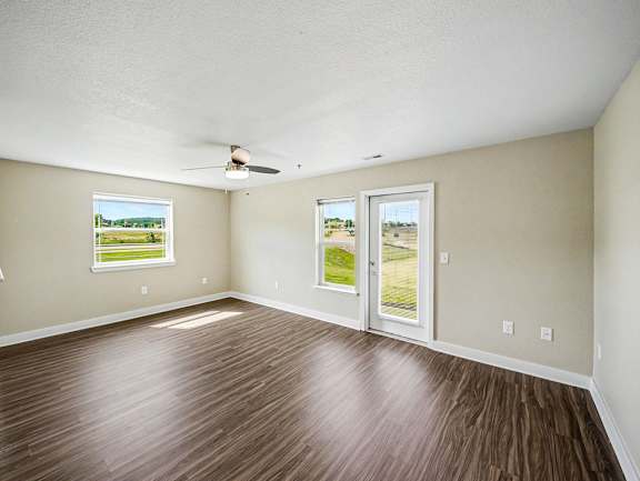 An enlarged living room with a ceiling fan and a french door to a patio at Chase Creek Apartment Homes, Huntsville, AL, 35811