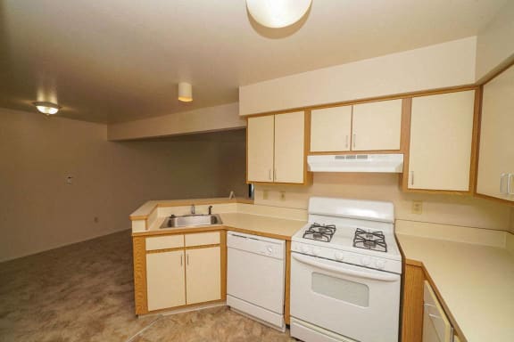 A kitchen with a breakfast bar and dishwasher at Canal Club Apartments, Lansing, MI