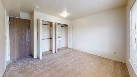 A spacious bedroom with carpet, and a closet with shelves at Canal Club Apartments, Lansing, MI, 48917