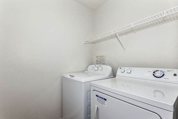 Laundry room with a white shelf at Colonial Pointe at Fairview Apartments, Bellevue