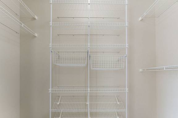 A walk-in closet with wardrobe organizers at Colonial Pointe at Fairview Apartments, Bellevue, NE, 68123