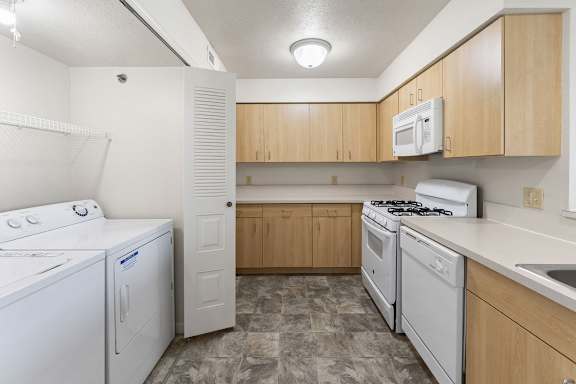 A kitchen with a washer and dryer at Colonial Pointe at Fairview Apartments, Bellevue, NE, 68123