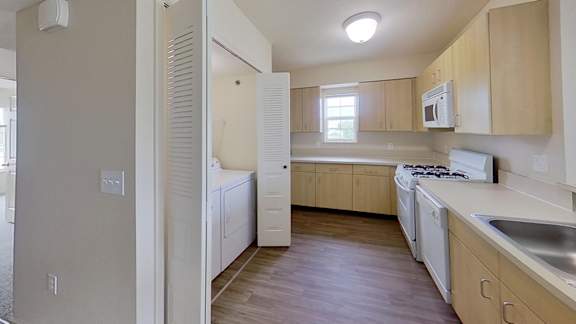 A kitchen with wooden cabinets and white appliances at Colonial Pointe at Fairview Apartments, Bellevue