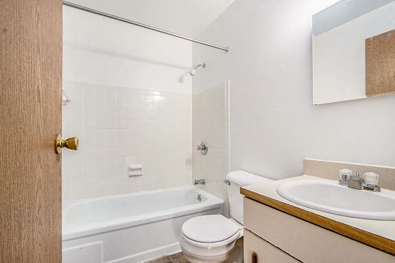 A bathroom with a bathtub/shower, vanity with sink, and toilet at Concord Place Apartments, Kalamazoo, MI