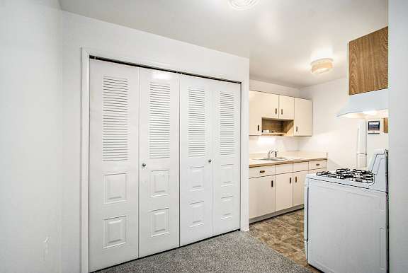 A kitchen with white appliances and wooden cabinets at Concord Place Apartments, Kalamazoo, MI