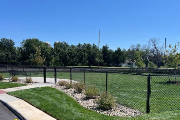 a dog park with a bench and fence at Copper Creek Apartments in Maize, KS