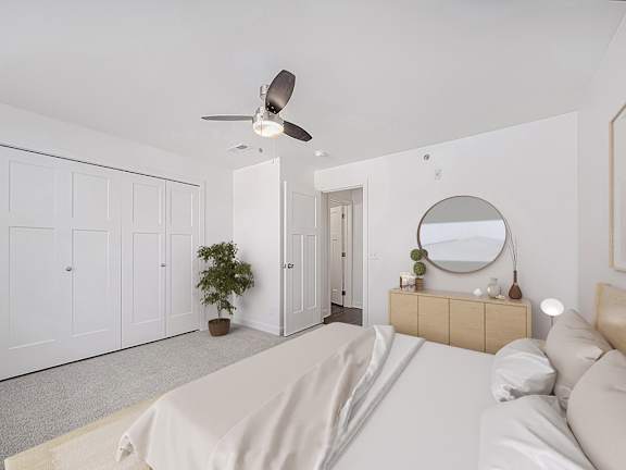 Spacious bedroom with ceiling fan and modern dresser at Copper Creek Homes Apartments, Maize, KS 67101