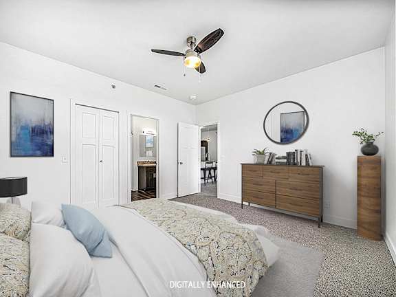 A 2nd bedroom with an ensuite, a bed, dresser, and ceiling fan A 2nd bedroom with an ensuite, a bed, dresser, and ceiling fan at Copper Creek Apartment Homes, Maize, Kansas