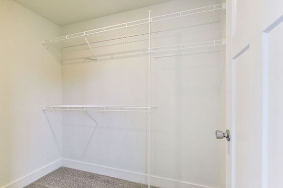 Walk-in closet with shelving system at Copper Creek Homes Apartments, Kansas