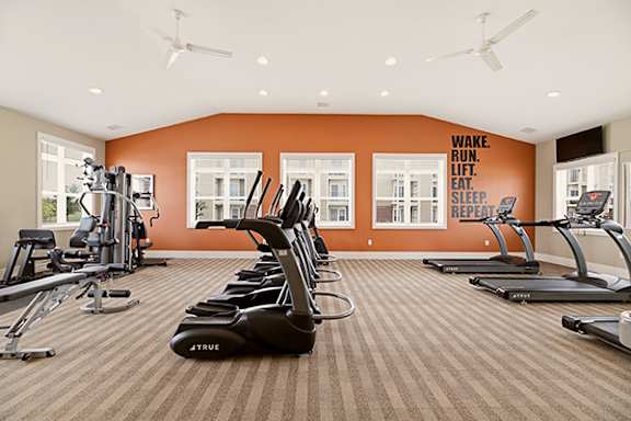 Fitness center with cardio equipment and weights at Copper Creek Homes Apartments, Maize, KS