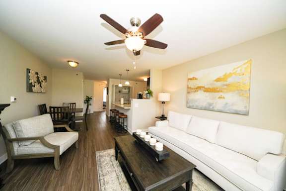 Spacious living room with white couch and artwork at Copper Creek Homes Apartments, Maize, 67101