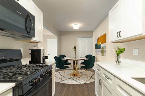 a kitchen with a stove and a table with chairs at Cordoba Apartments in Farmington Hills, MI 48334