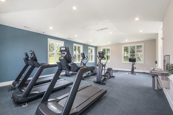 a gym with treadmills and other exercise equipment at The Crossings Apartments in Kentwood, MI