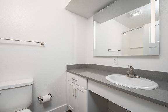 A renovated bathroom with a large vanity area and mirror at The Crossings Apartments, Grand Rapids