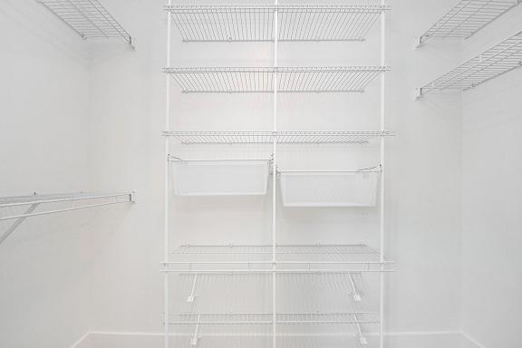 A walk-in closet with wardrobe organizers at The Crossings Apartments, Grand Rapids