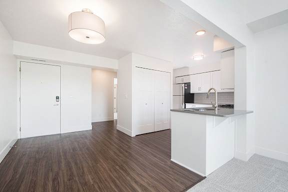 A kitchen and dining area with white cabinets and a hard-surface floor at The Crossings Apartments, Grand Rapids