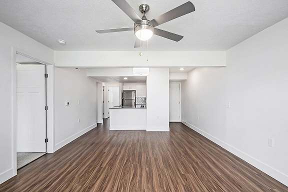 A living room with a ceiling fan at The Crossings Apartments in Grand Rapids, MI
