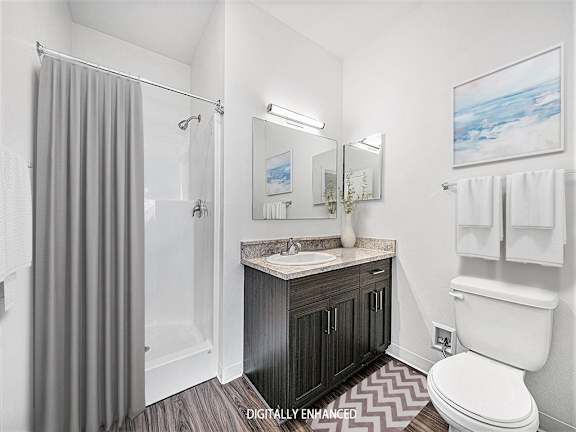 A bathroom with a sink, toilet, and shower A bathroom with a sink, toilet, and shower at Dodson Pointe Apartment Homes, Rogers