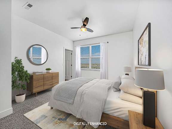 A bedroom with a bed, a ceiling fan, and a window with blinds A bedroom with a bed, a ceiling fan, and a window with blinds at Dodson Pointe Apartment Homes, Rogers