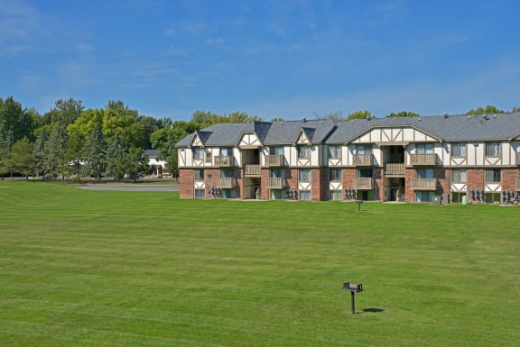 a large apartment building with a green lawn in front of it at Huntington Place Apartments, Michigan, 48732