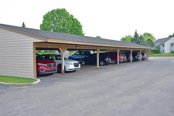 a car dealership with a row of cars in front of it at Grand Bend Club Apartments, Grand Blanc