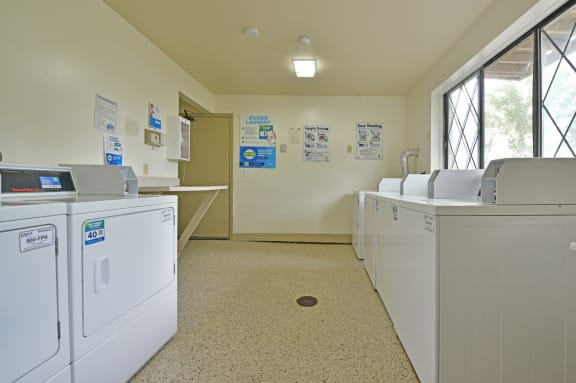 a washer and dryer room with washing machines and dryers in a roomat Woodland Place, Michigan, 48640