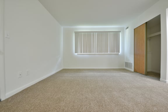 a empty room with carpet and a window