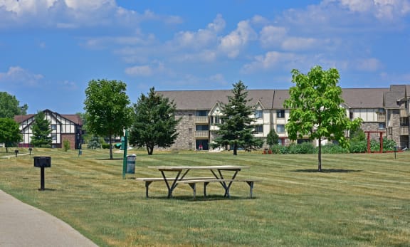 a picnic table in a park in front of an apartment buildingat Thornridge Apartments, Grand Blanc