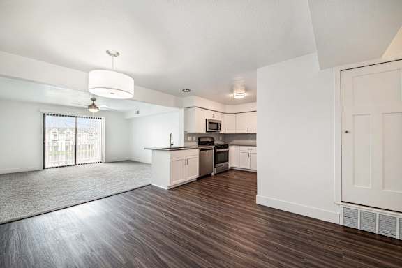 kitchen with hard surface floors and living room with plush carpeting at Dupont Lakes Apartments in Fort Wayne, IN