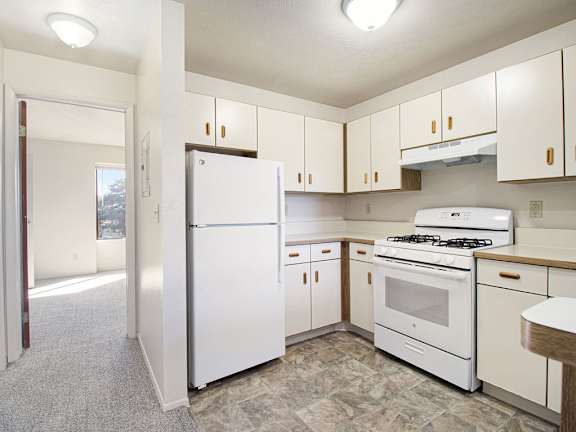 A kitchen with white refrigerator and stove at Dupont Lakes Apartments in Fort Wayne, IN