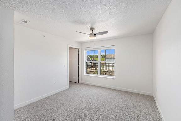 Bedroom with plush carpeting and large window at Eagle Ridge Apartment Homes, Traverse City, 49685
