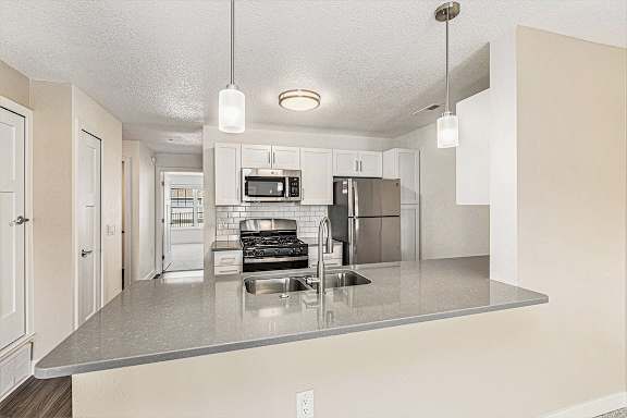 Living room with carpet leading to kitchen at Eagle Ridge Apartment Homes,  Michigan 49685