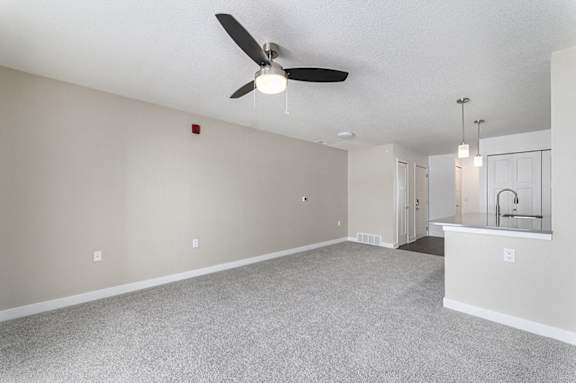 A living room with a ceiling fan and a carpeted floor at Eagle Ridge Apartment Homes, Traverse City, Michigan