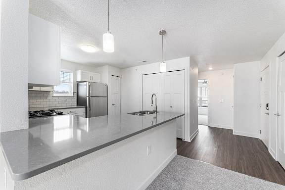 A modern kitchen with white cabinets and a grey countertop at Eagle Ridge Apartment Homes, Traverse City