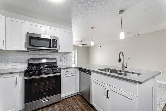A kitchen with a stove, oven, microwave, and sink at Eagle Ridge Apartment Homes, Traverse City, Michigan