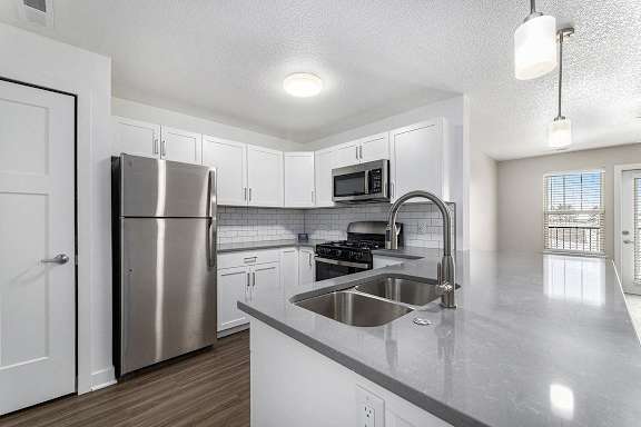 A kitchen with a stainless steel refrigerator and a sink at Eagle Ridge Apartment Homes, Traverse City, Michigan